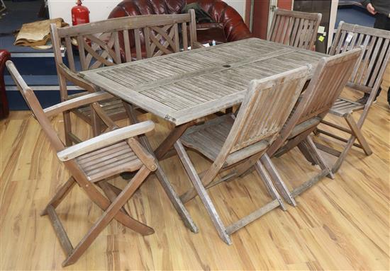 A teak garden table, bench and five chairs Table 150cm